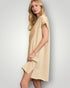 Woman wearing a beige dress against a plain background