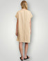 Woman wearing a beige dress with a plain background