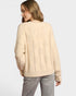 Woman wearing a beige sweater on a light gray background