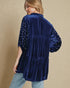 Navy velvet jacket with pearl embellishments on a beige background