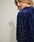 Navy blue velvet dress with pearl embellishments on a plain background
