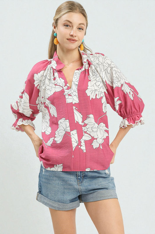 Woman wearing a pink floral blouse and denim shorts on a white background