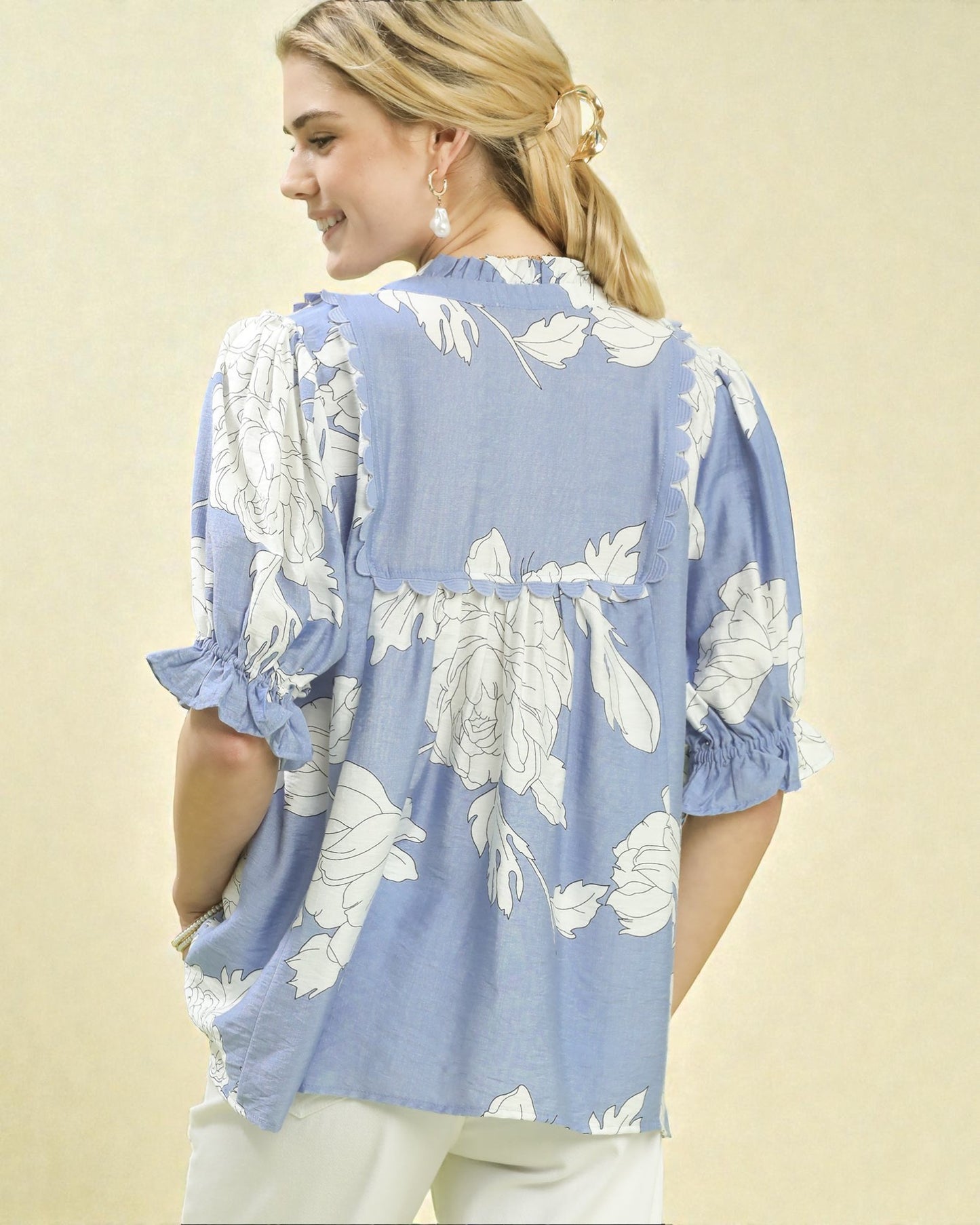 Woman wearing a blue floral blouse against a beige background