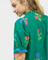 Green blouse with colorful floral embroidery on a plain background
