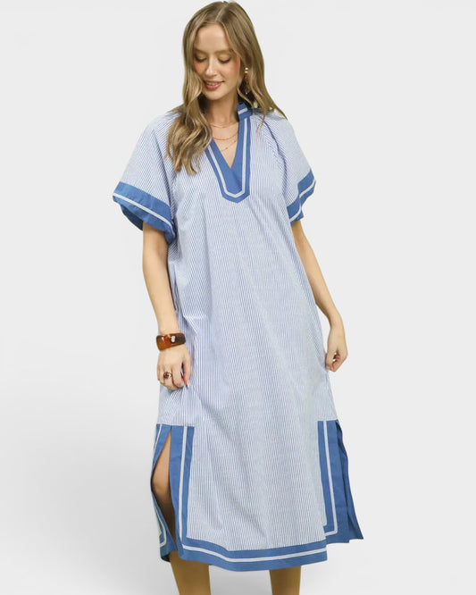 Woman wearing a blue and white patterned dress on a plain background