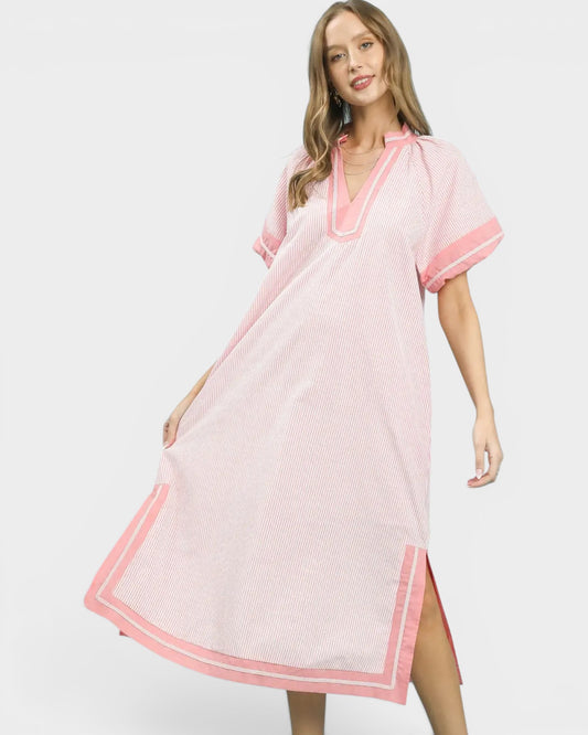 Woman wearing a pink dress with white polka dots on a white background