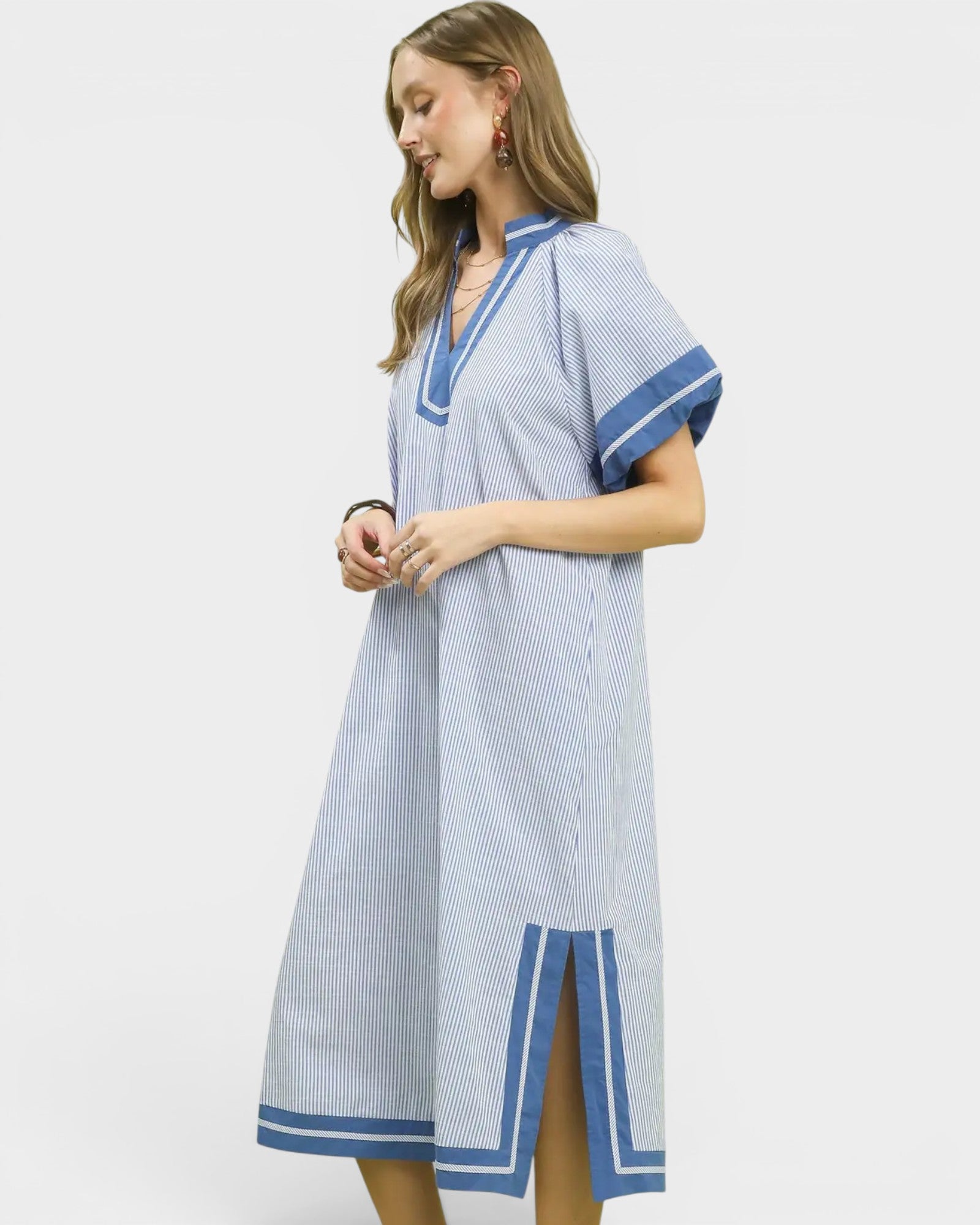 Woman wearing a blue and white striped dress on a plain background