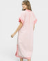 Woman wearing a pink dress with white stripes on a plain background