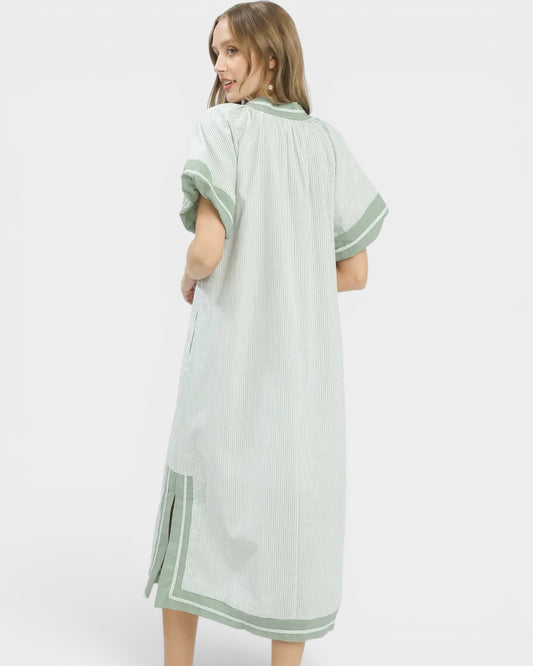 Woman wearing a light green dress with white background