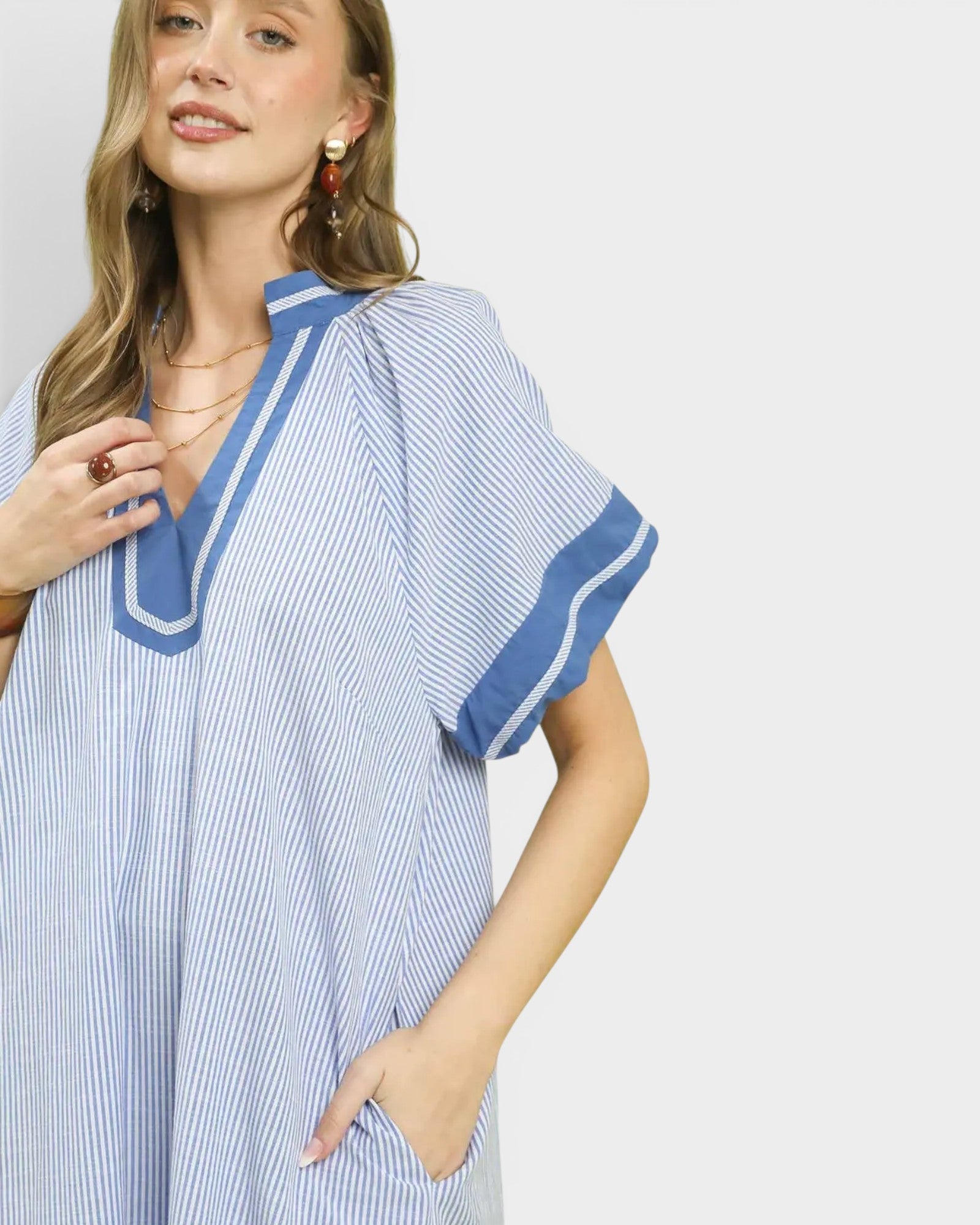 Woman wearing a blue and white striped dress with a plain background