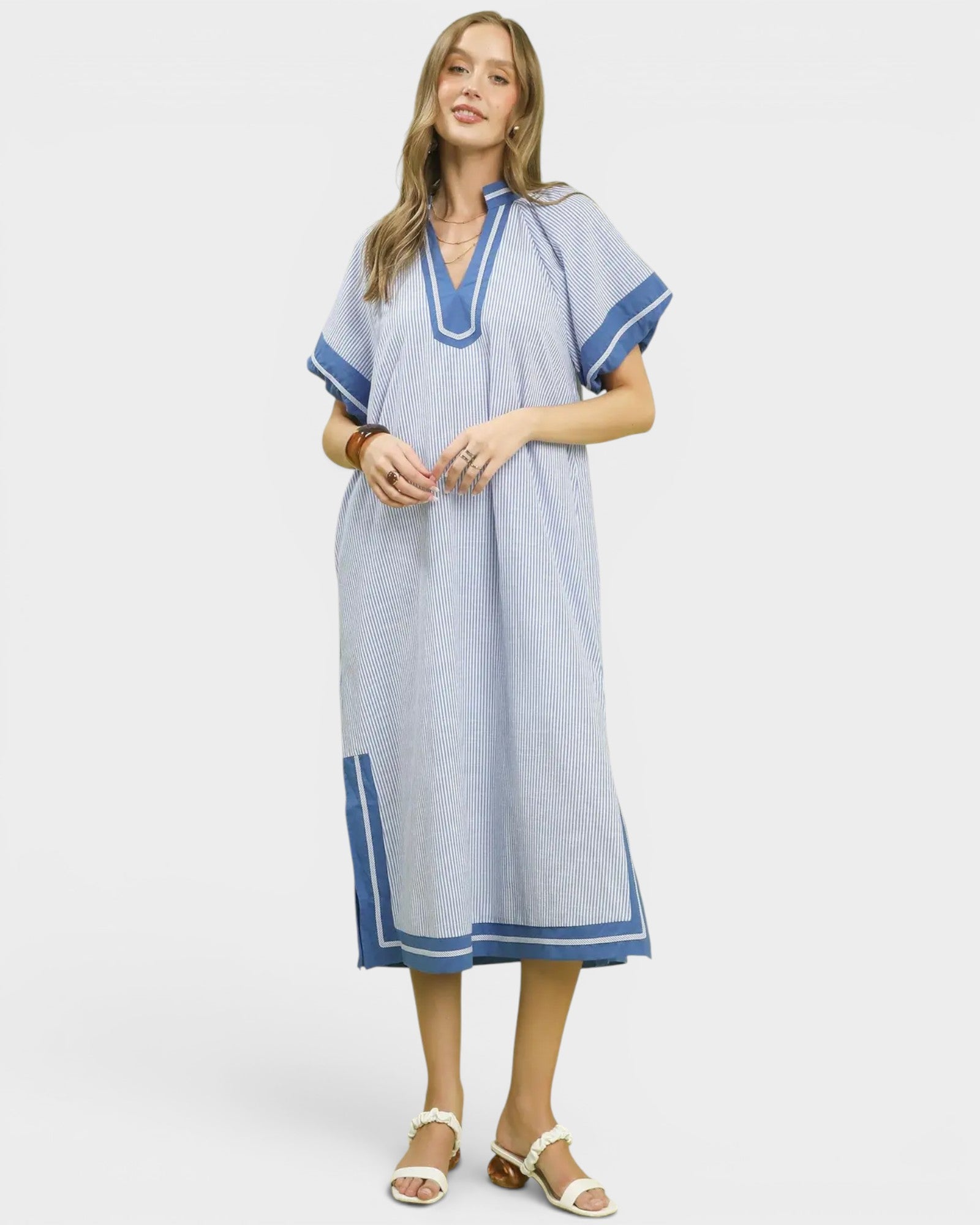 Woman wearing a blue dress with white trim on a white background