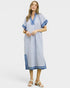 Woman wearing a blue dress with white trim on a white background