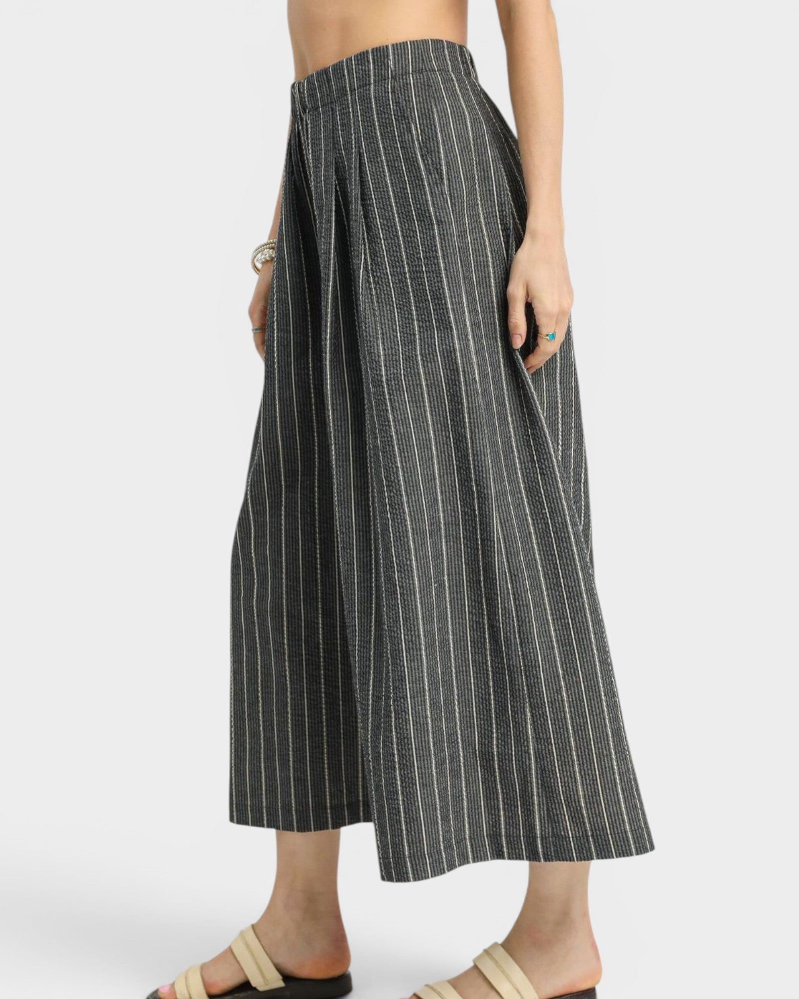 Pinstripe wide-leg pants worn by a person on a white background