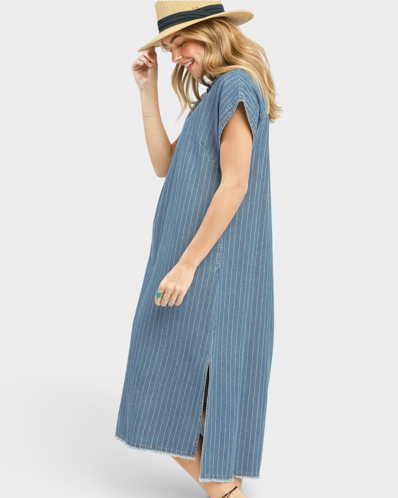 Woman wearing a blue striped dress and straw hat on a white background