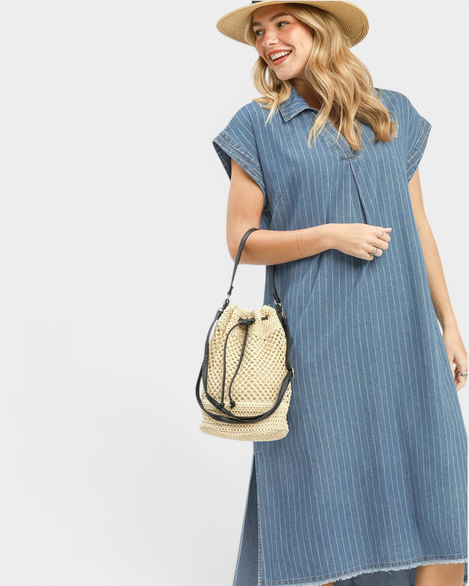 Woman wearing a blue striped dress and straw hat on a white background