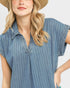 Woman wearing a blue pinstripe dress with a neutral background