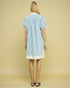 Woman wearing a blue and white striped dress on a beige background