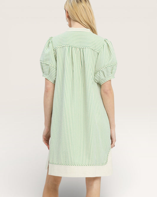 Person wearing a green and white striped shirt against a plain background