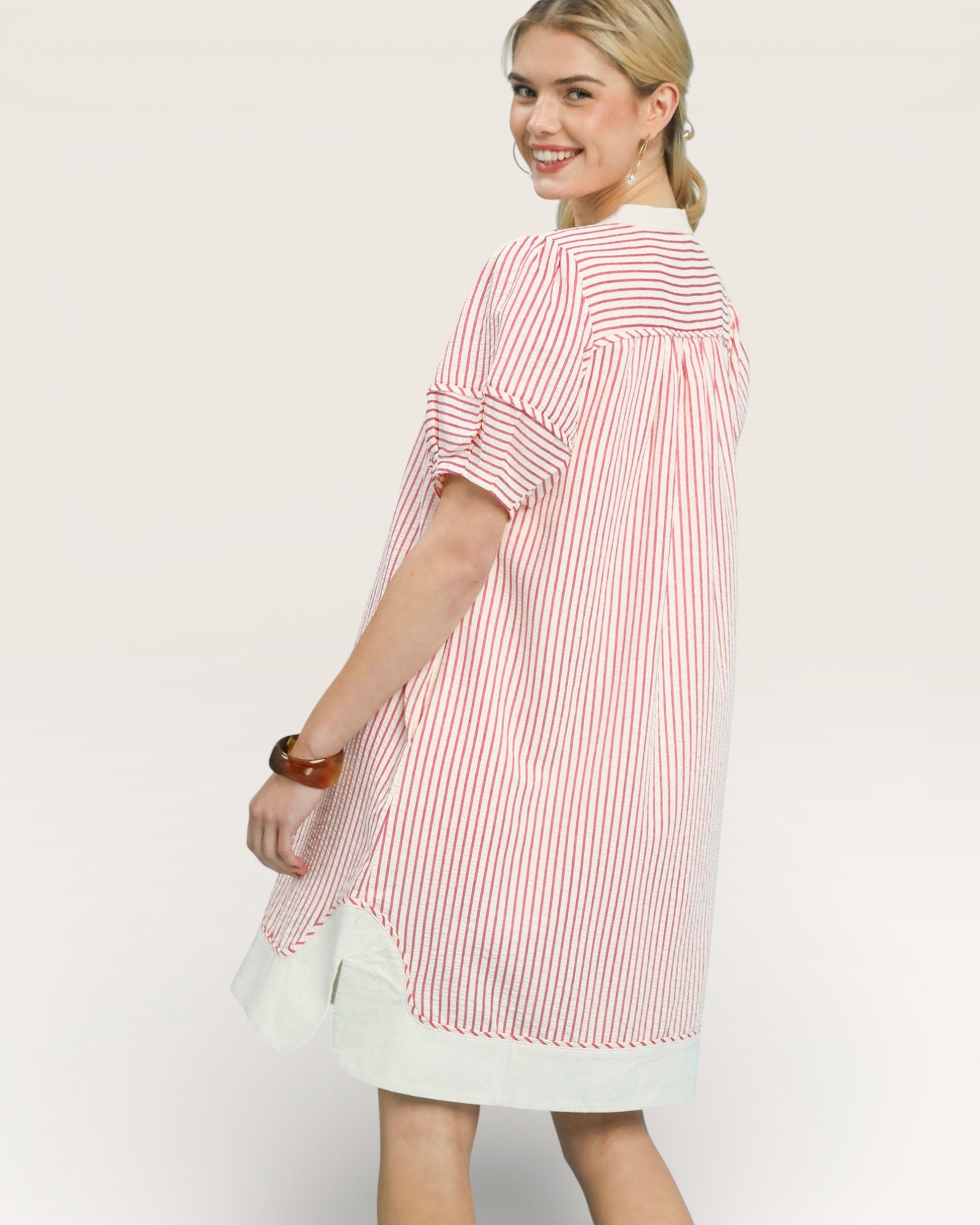 Woman wearing a red and white striped shirt against a plain background