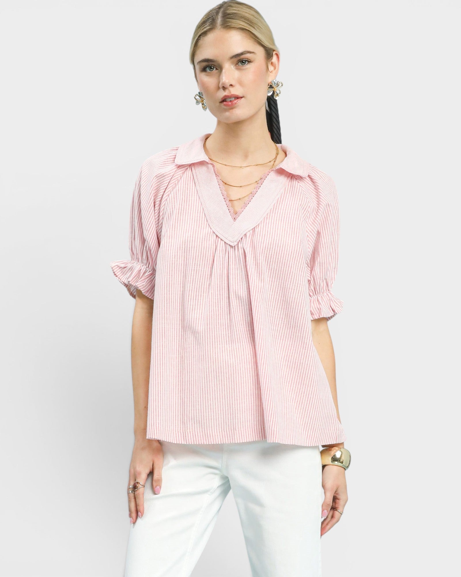 Woman wearing a pink striped blouse with a white background