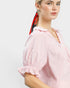 Woman wearing a pink striped blouse with a plain background