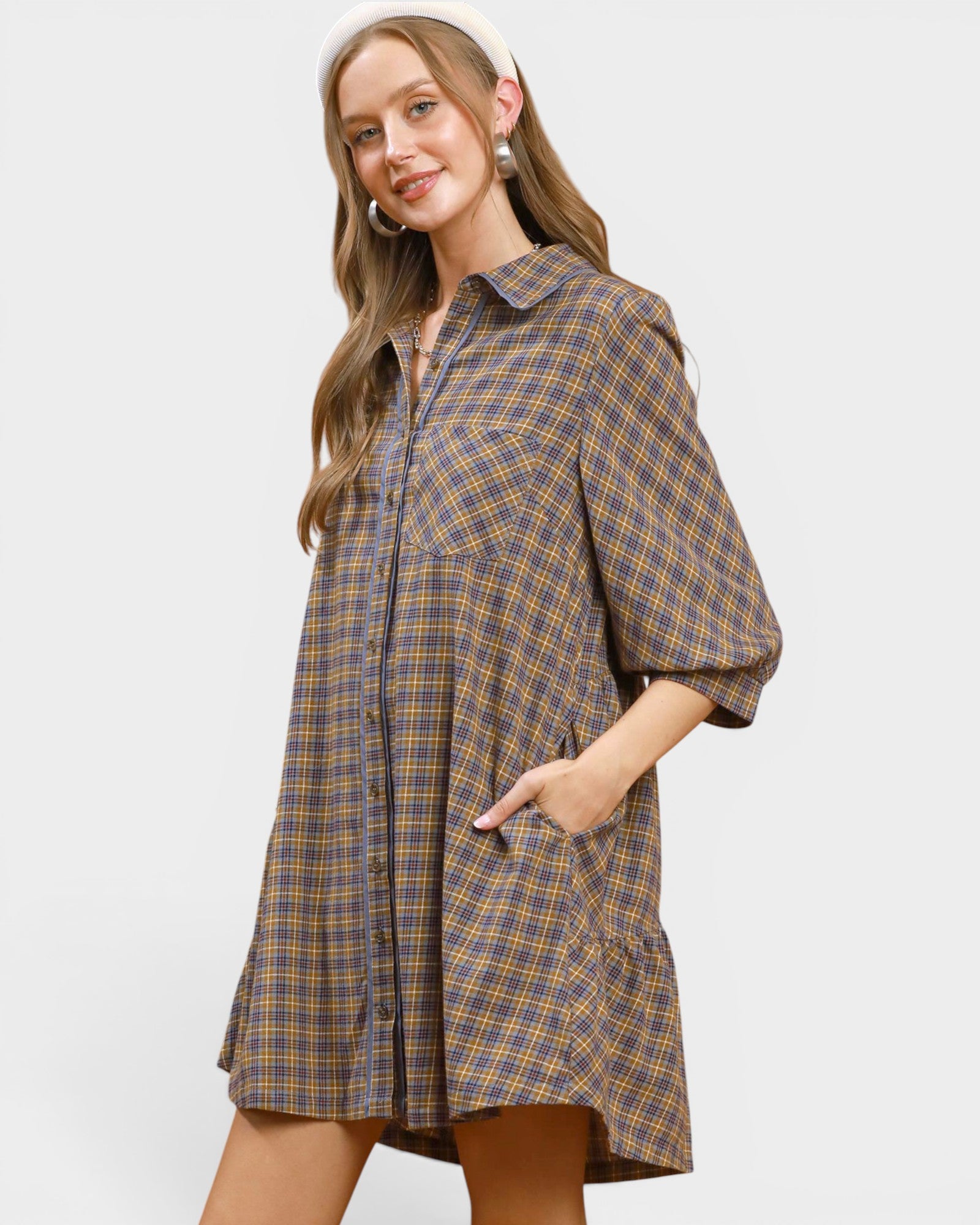 Woman wearing a plaid dress against a white background