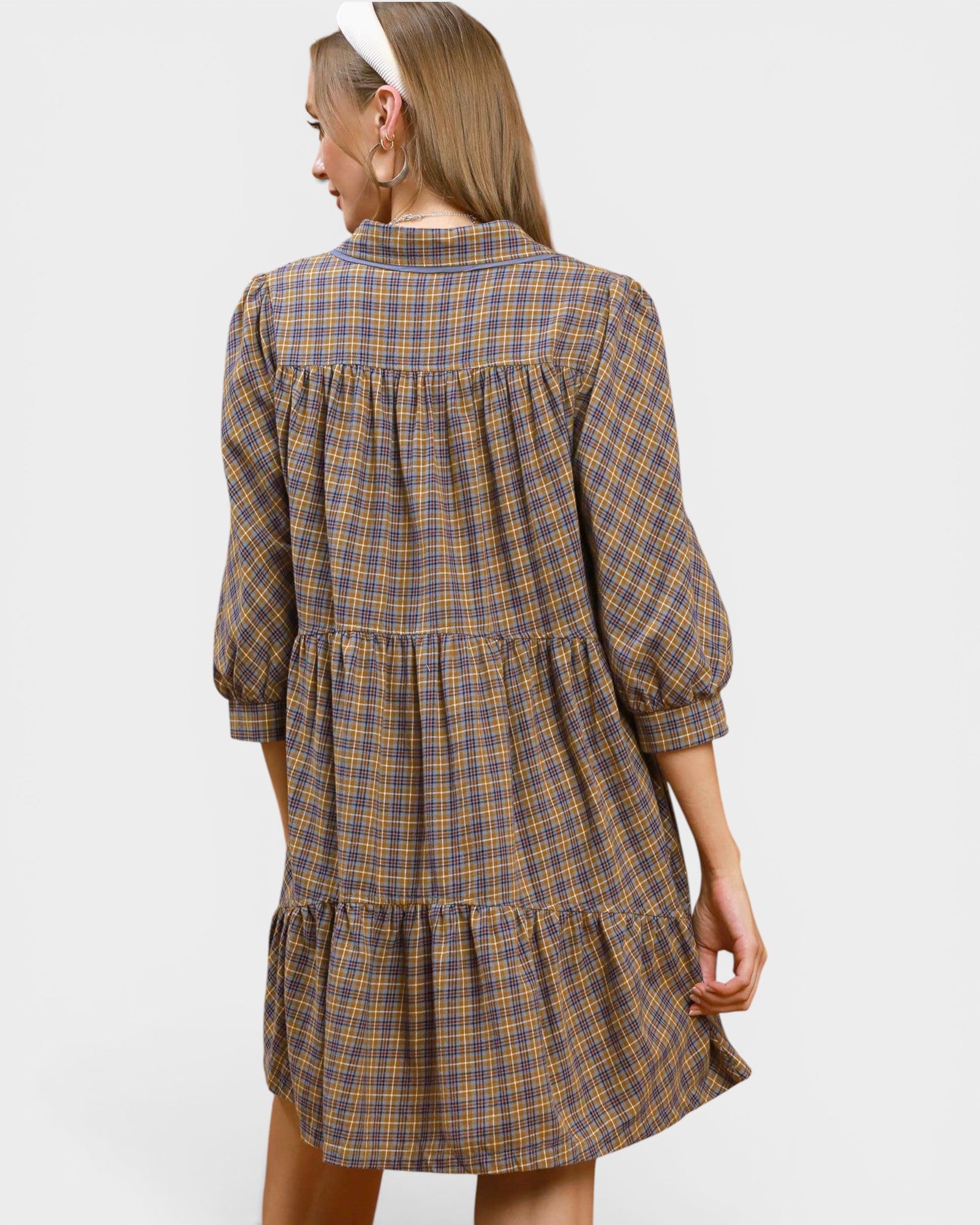 Woman wearing a plaid dress with a plain background