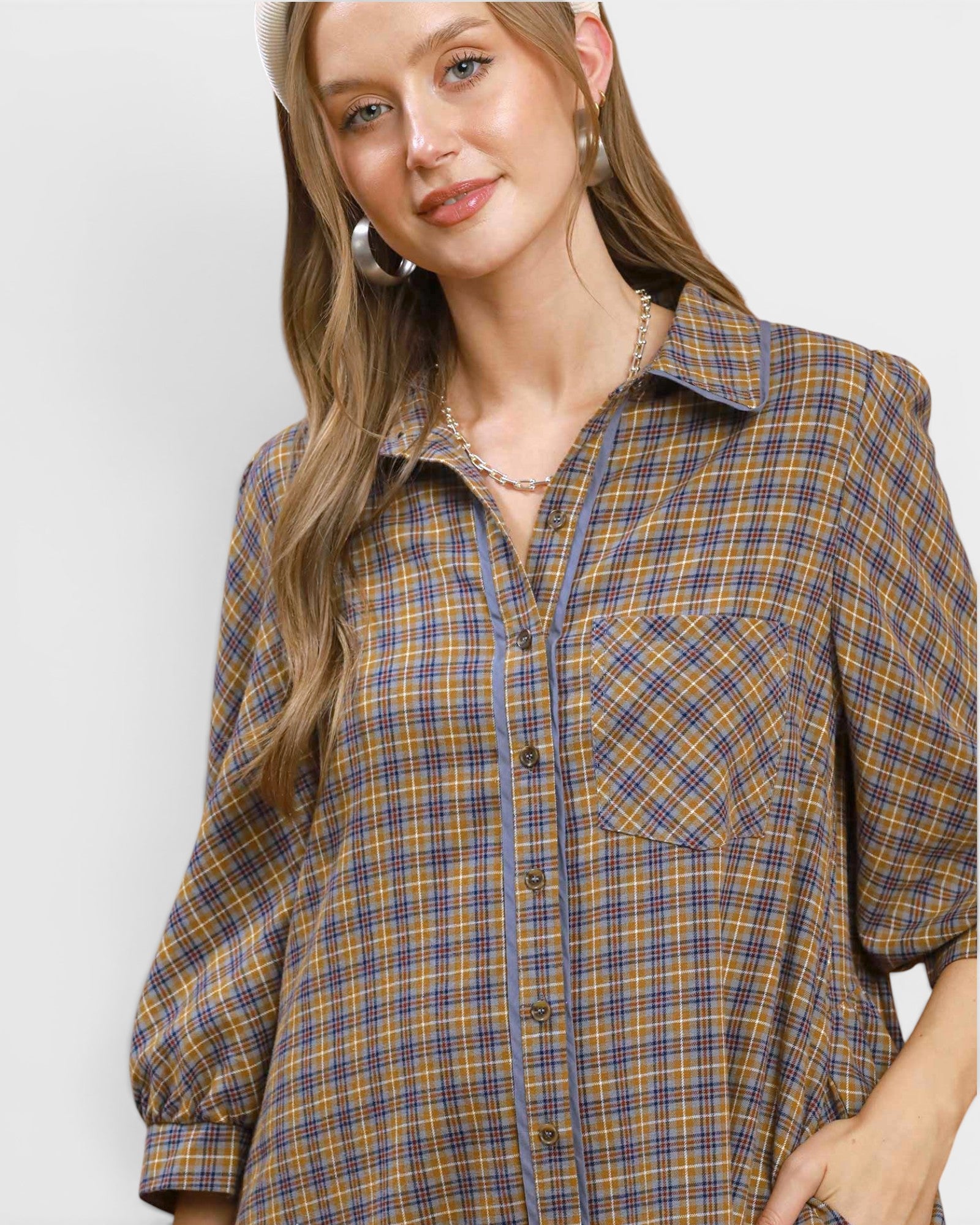 Woman wearing a plaid shirt against a white background