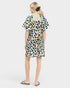 Woman wearing a colorful polka dot dress on a white background