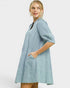 Woman wearing a light blue dress with a plain background