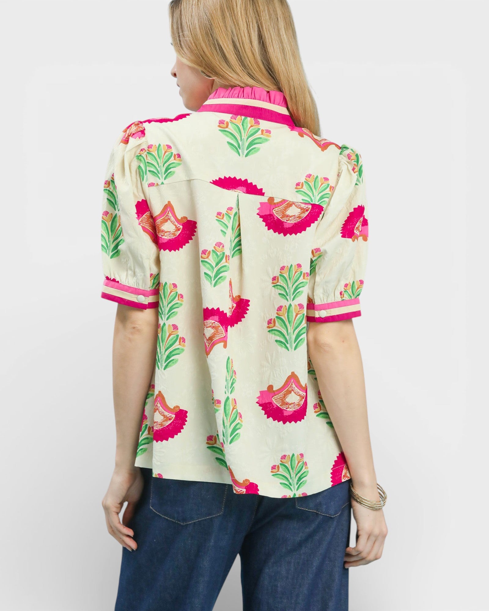 Woman wearing a colorful floral blouse with a plain background