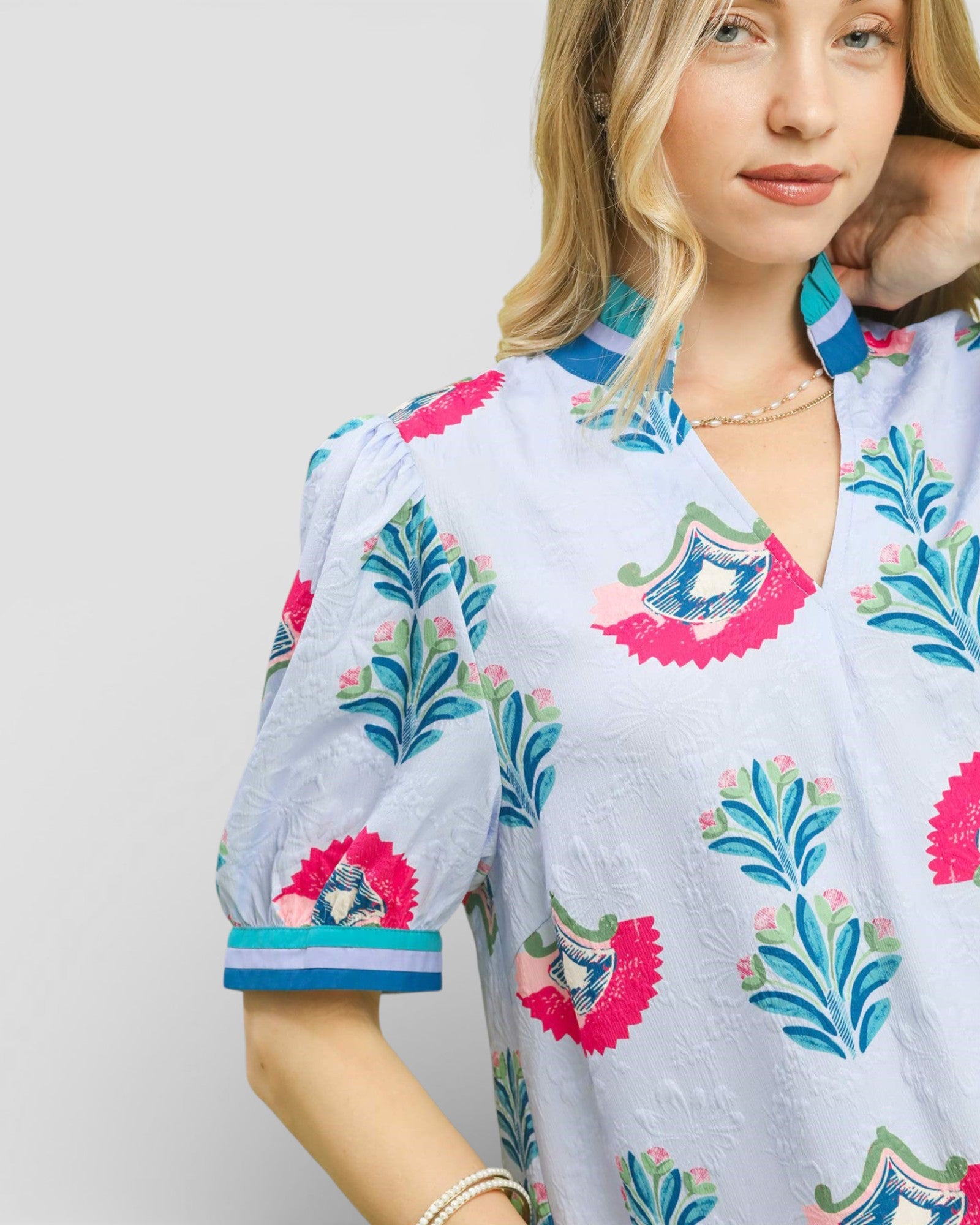 Woman wearing a colorful floral dress with a plain background