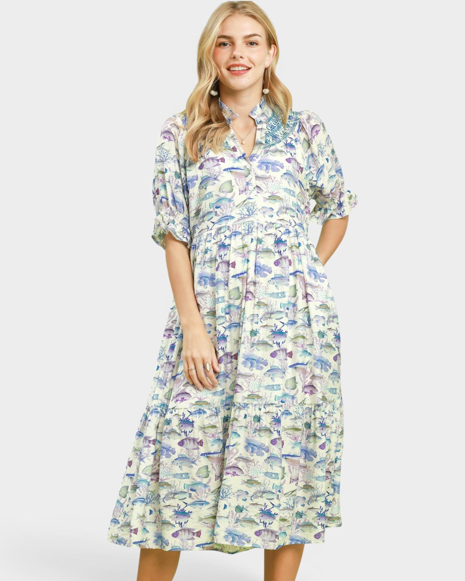 Woman wearing a fish print dress on a white background