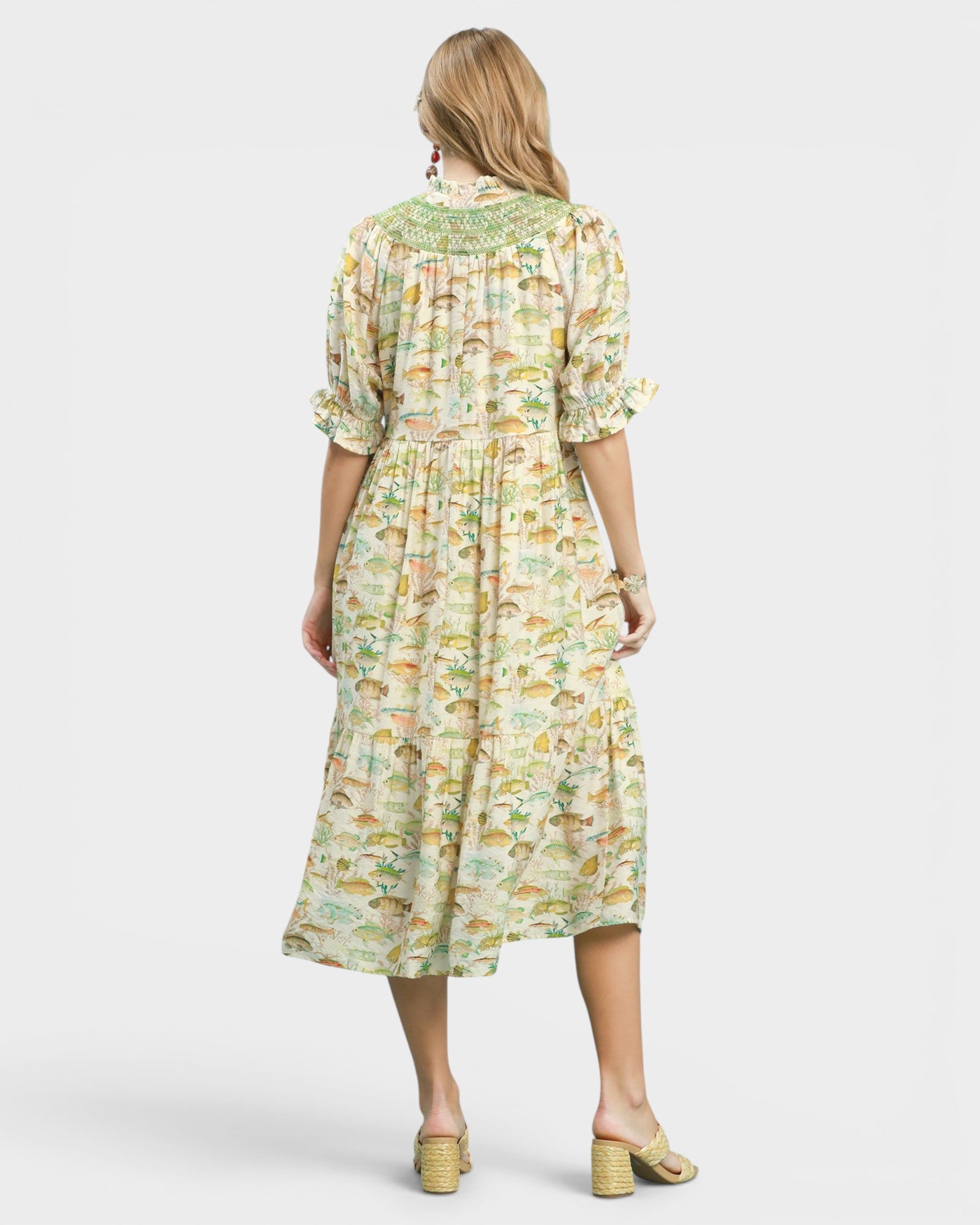 Woman wearing a fish print dress on a white background