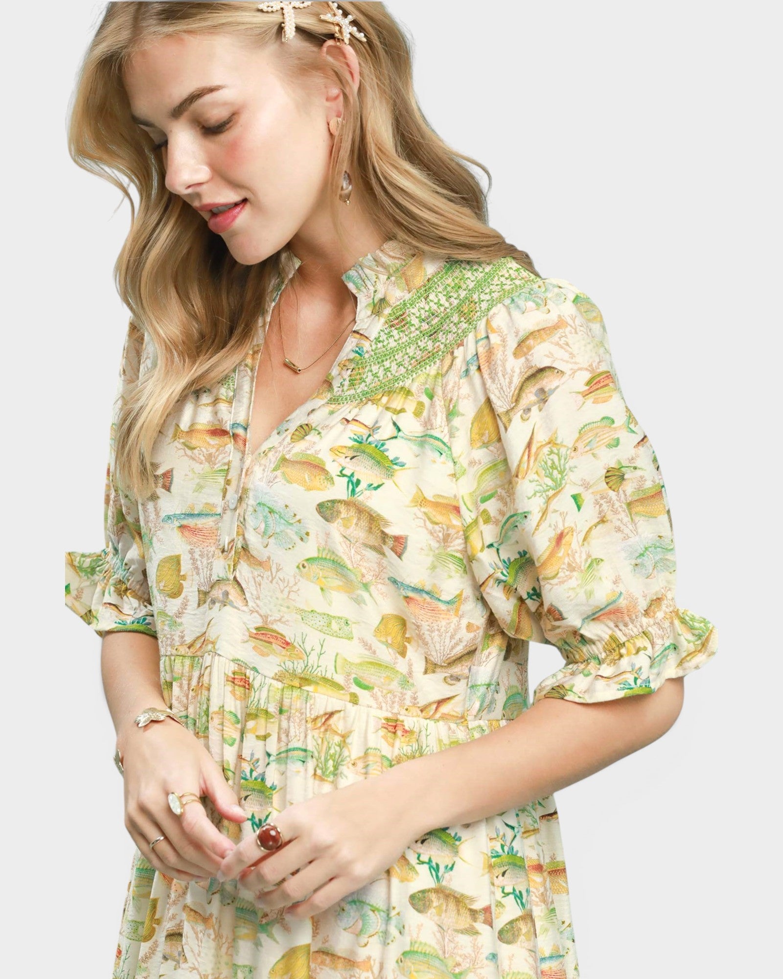 Woman wearing a fish print dress on a white background