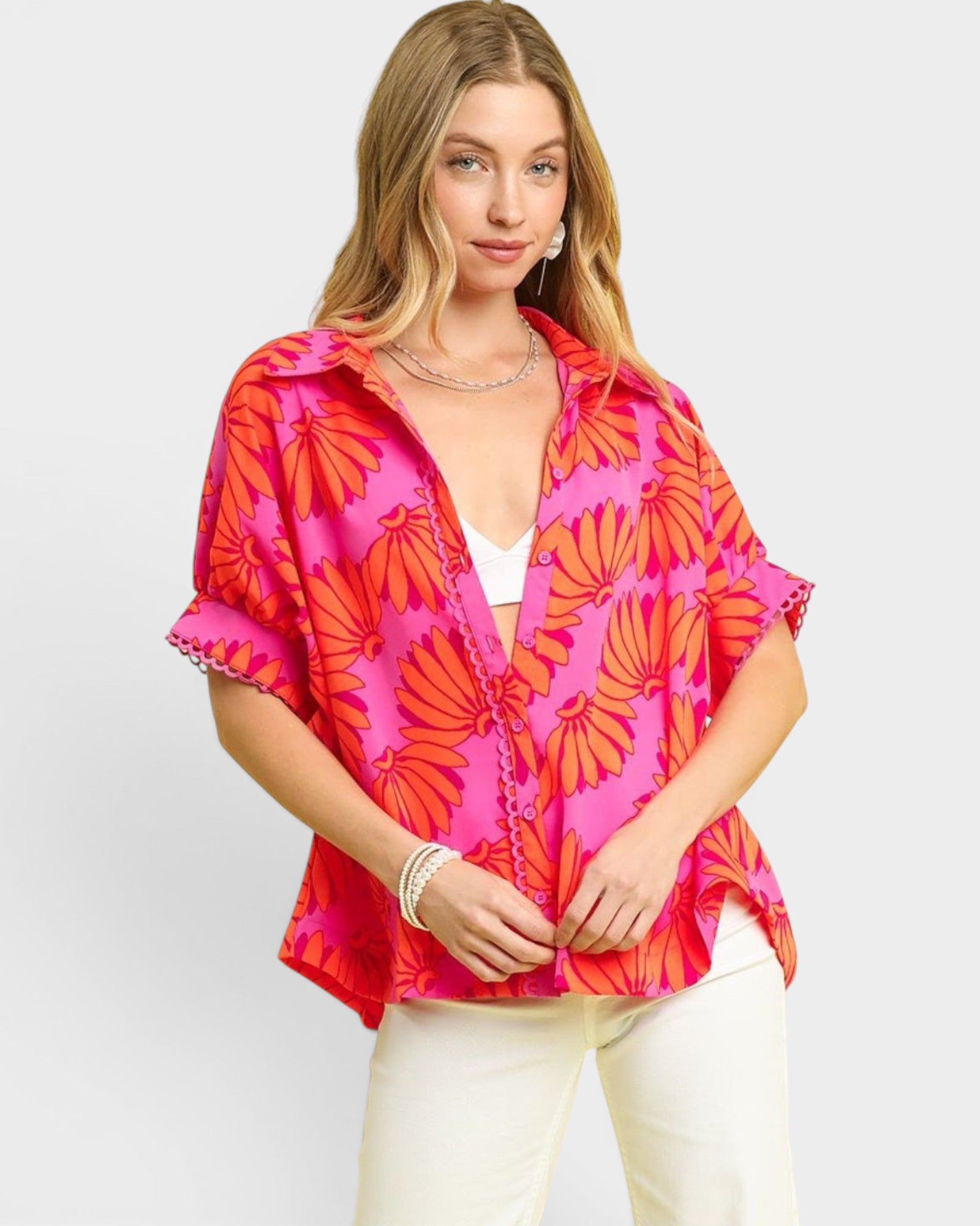 Woman wearing a vibrant pink and orange floral kimono against a white background