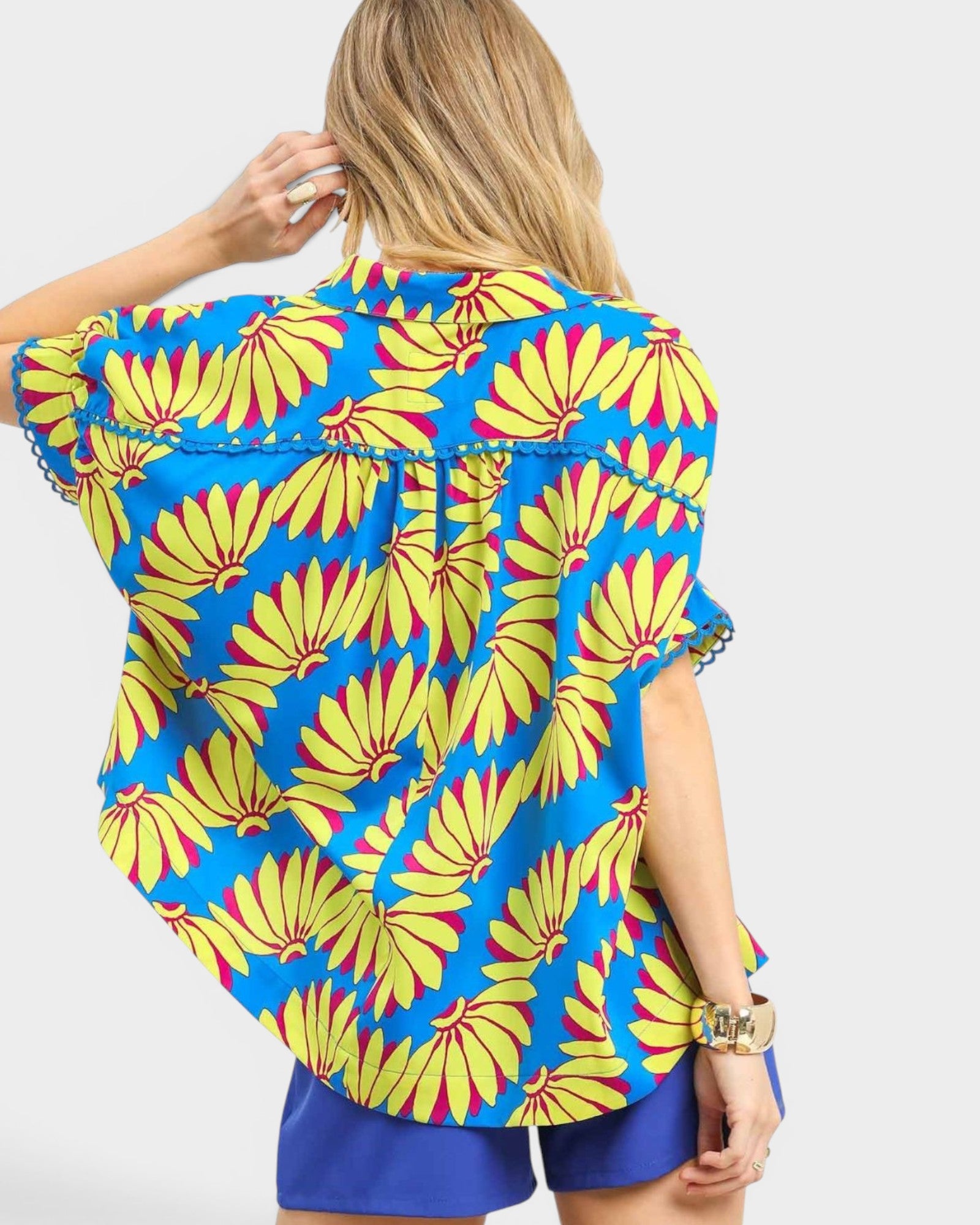 Woman wearing a colorful floral patterned top with blue background