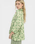 Woman wearing a green and white patterned blouse on a white background