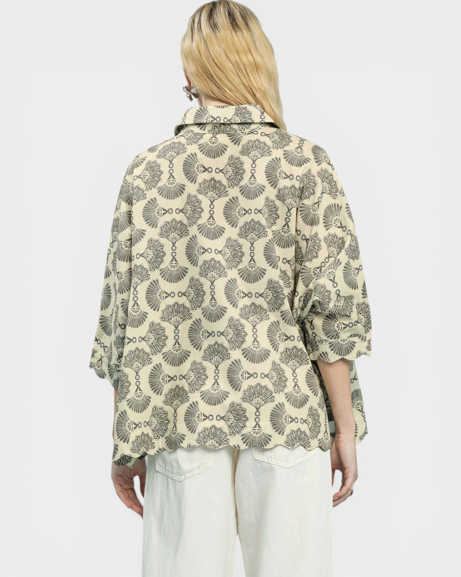 Person wearing a patterned shirt with a plain background