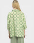 Person wearing a green and white patterned shirt on a light gray background