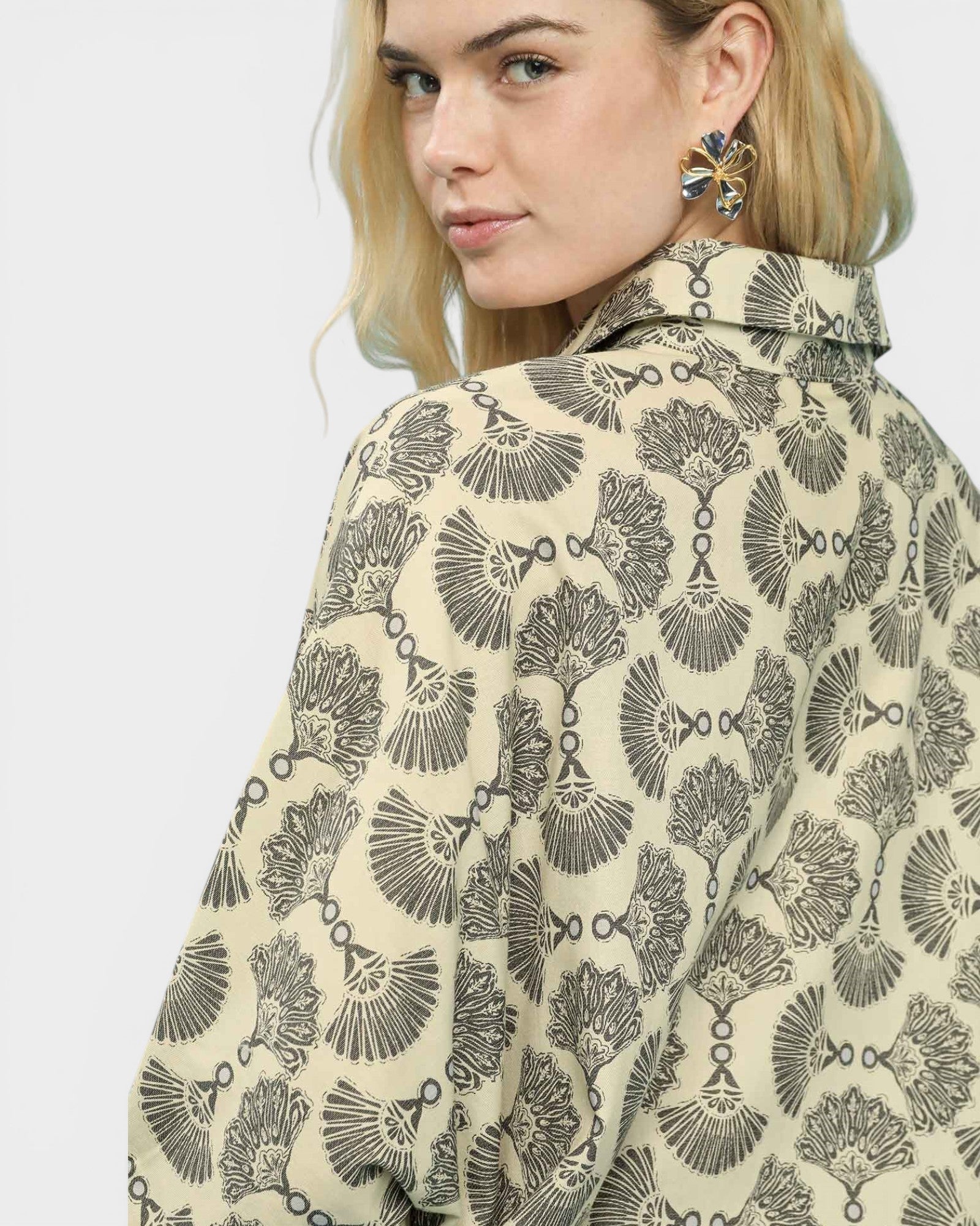 Woman wearing a patterned shirt with a neutral background