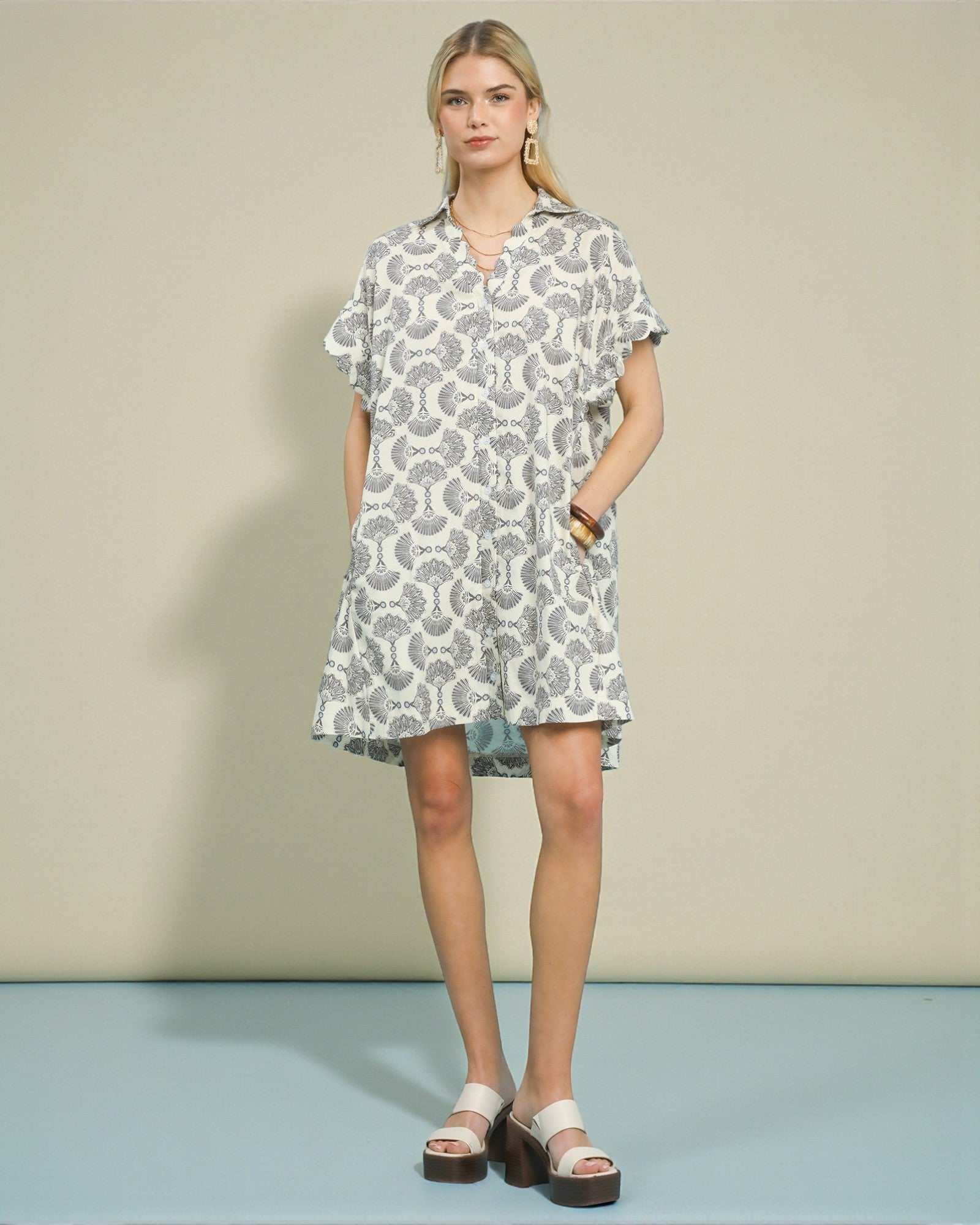 Woman wearing a patterned dress against a plain background