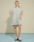 Woman wearing a patterned dress against a plain background