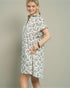 Woman wearing a patterned dress against a plain background
