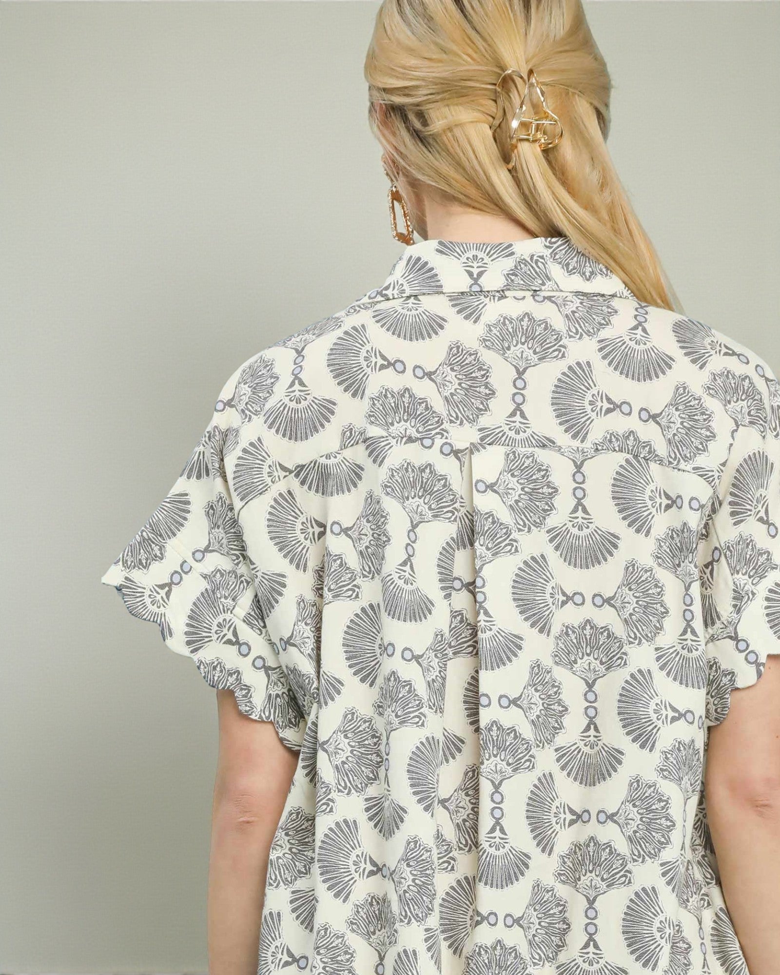 Person wearing a patterned shirt with a neutral background