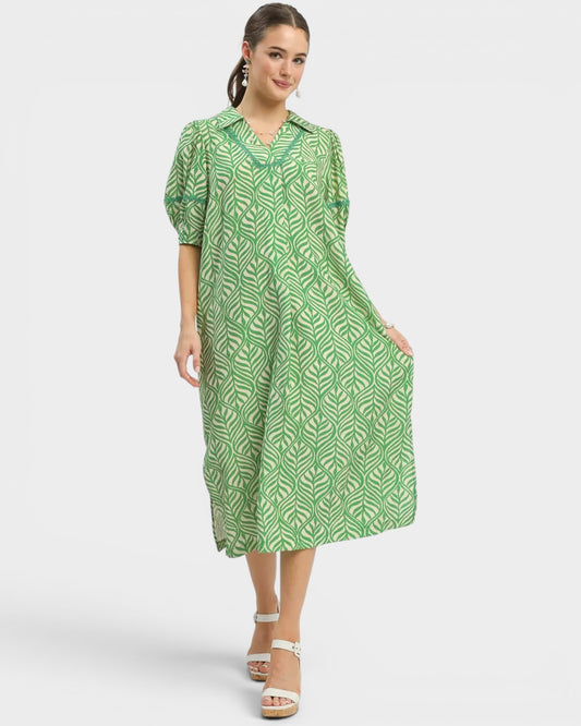 Woman wearing a green patterned dress on a white background