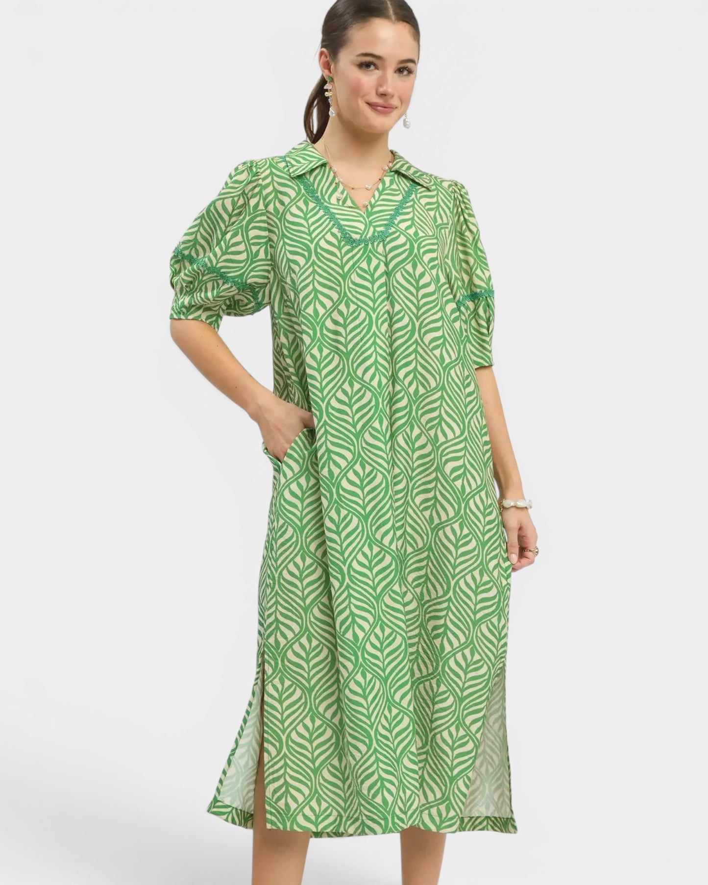 Woman wearing a green patterned dress on a white background