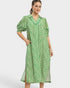 Woman wearing a green patterned dress on a white background