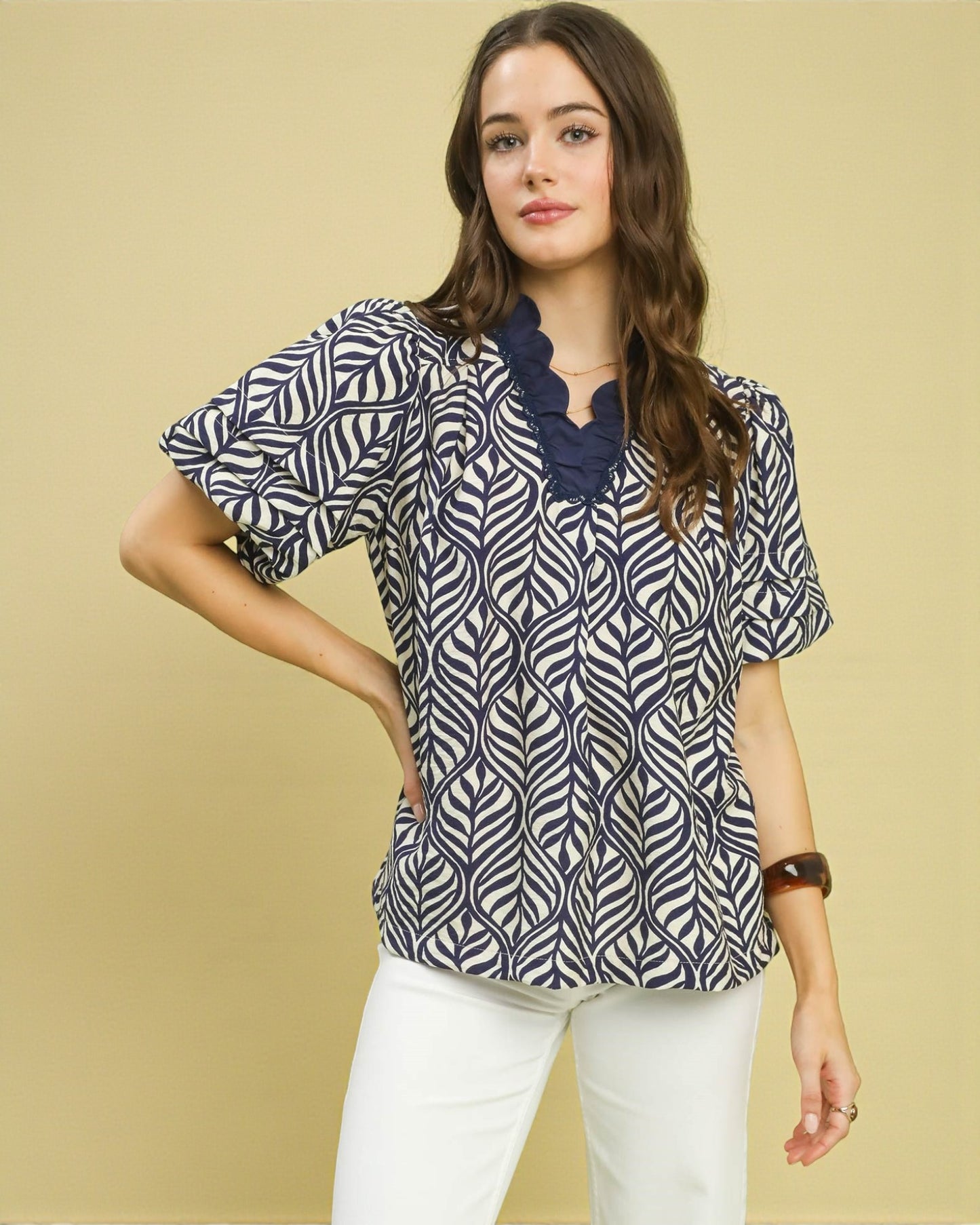 Woman wearing a patterned blouse with a plain background