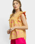 Woman wearing a yellow floral top with ruffled sleeves on a white background